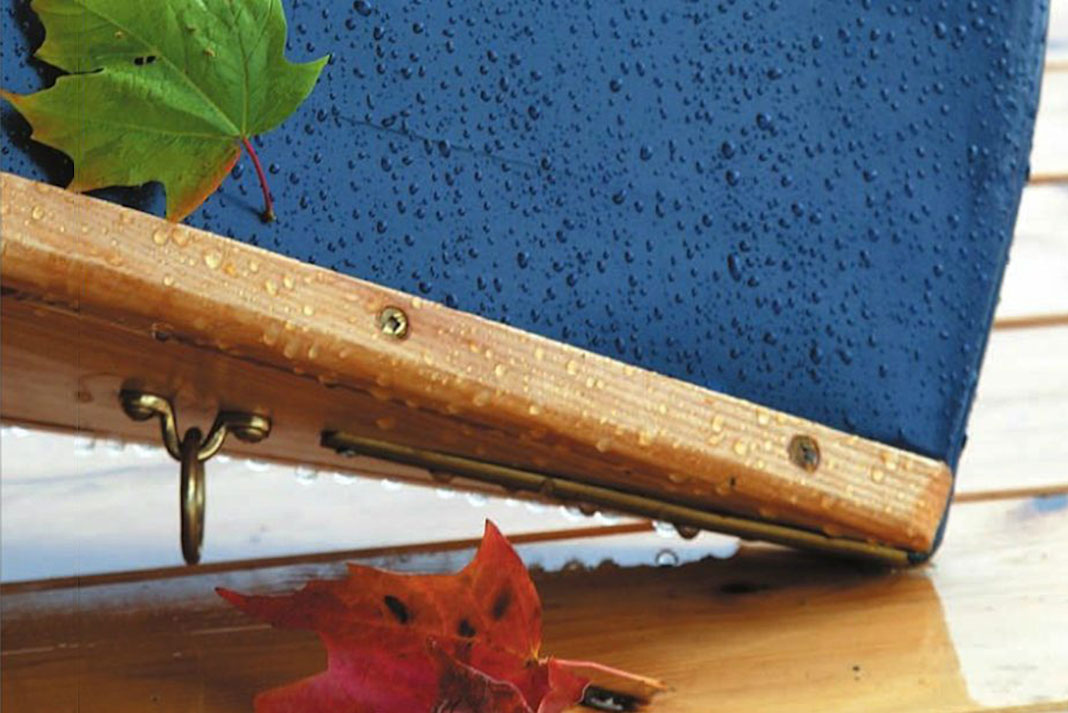 an blue upended canoe bow with maple leaves on wet decking