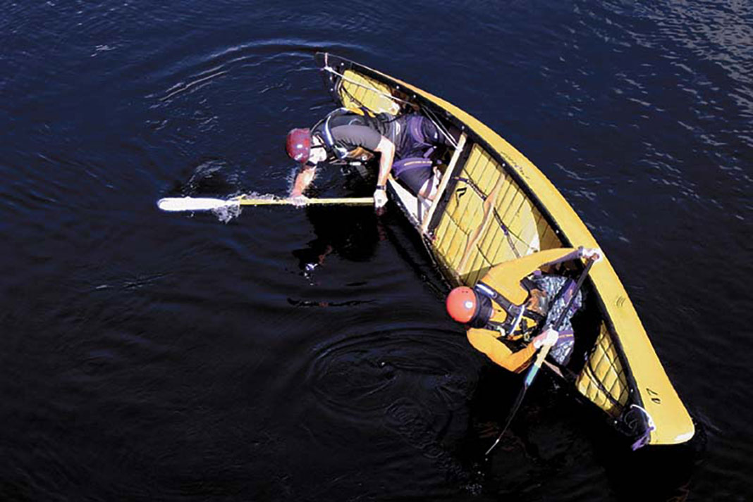 two canoeists perform a tandem canoe roll
