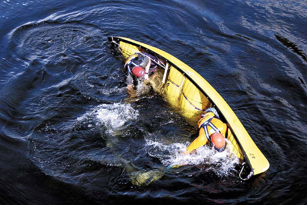 two canoeists perform a tandem canoe roll