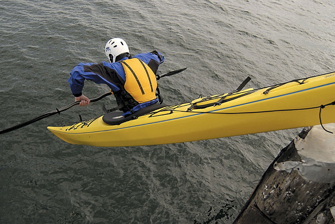 man in a sea kayak demonstrates the seal launch
