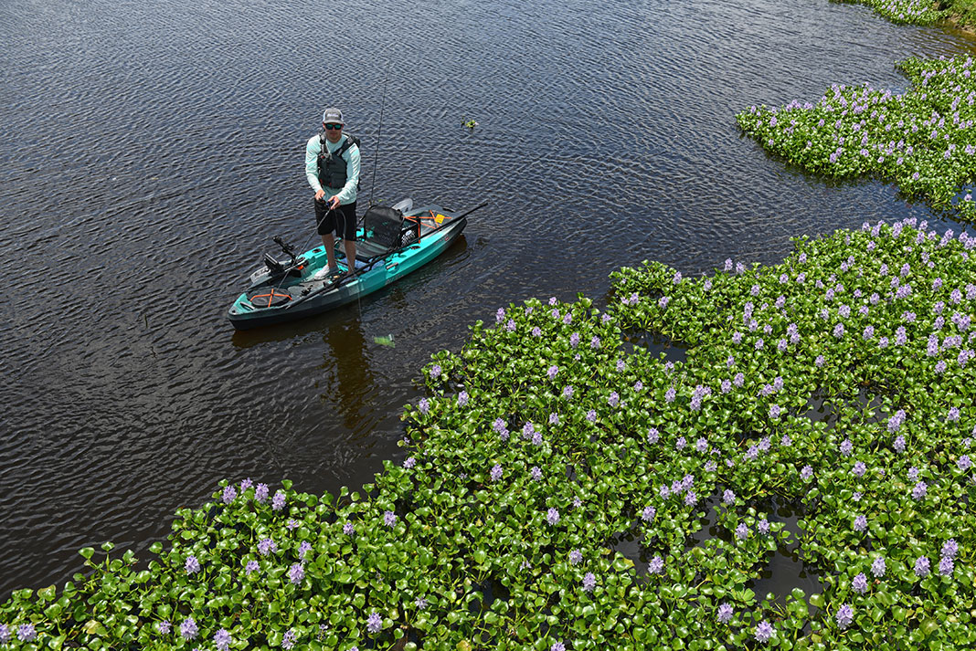 man stands and fishes from a compact fishing kayak