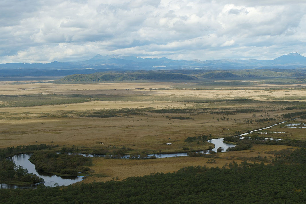 River running through marshland with distant hills in background