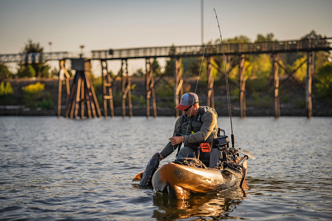 man catches and releases a Chinook salmon from a kayak