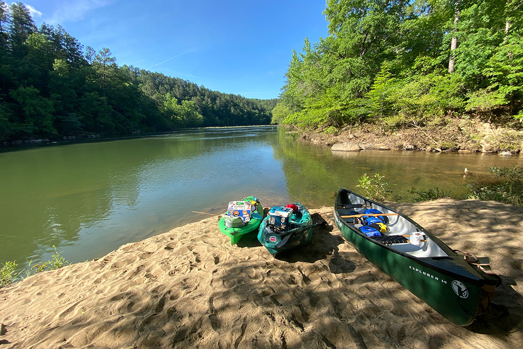 kayaks and canoe rest on the bank of the Cahaba River in Alabama