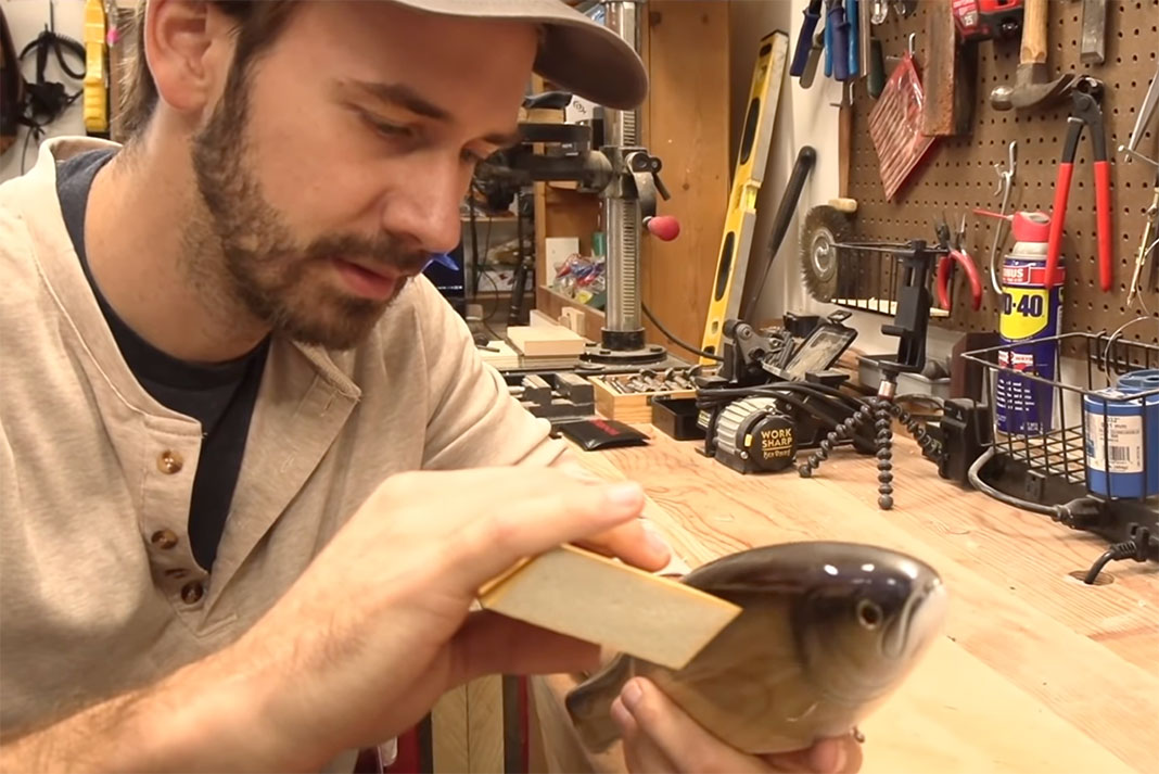 man prepares to sand off the clear coat from a $1,200 fishing lure