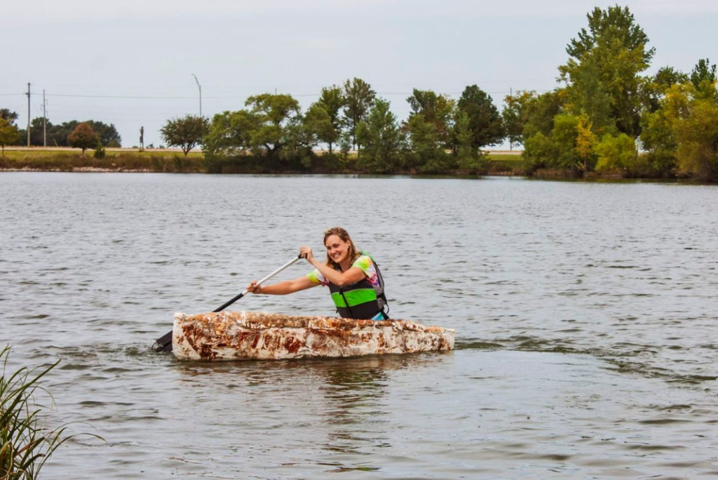 Katy Ayers paddles a mushroom canoe around a lake
