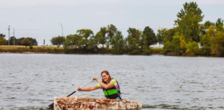 Katy Ayers paddles a mushroom canoe around a lake