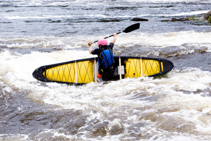 Beginner canoeist capsizes in whitewater river