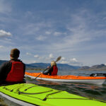 Best Delta Kayaks For 2026 Two people paddling green and orange touring kayaks