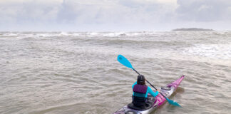 Woman paddling purple touring kayak