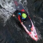 Best Pyranha Kayaks For 2026 Overhead shot of someone paddling a whitewater kayak through a wave