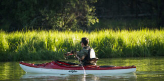 Man paddling red recreational sit-inside kayak