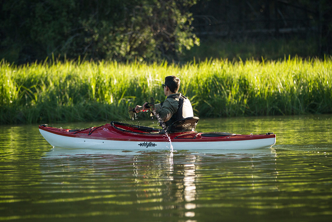 Man paddling red recreational sit-inside kayak