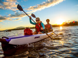 Man and woman paddling tandem inflatable kayak