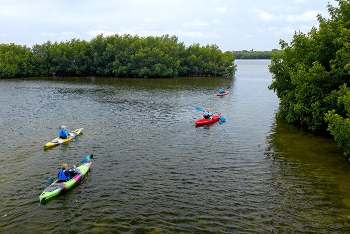 Three kayaks being paddled on a lake