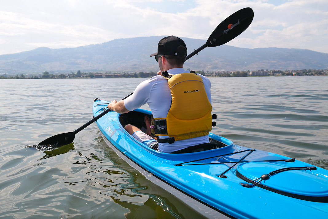Man paddling blue kayak