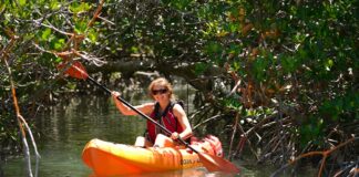 Woman paddling orange sit-on-top kayak