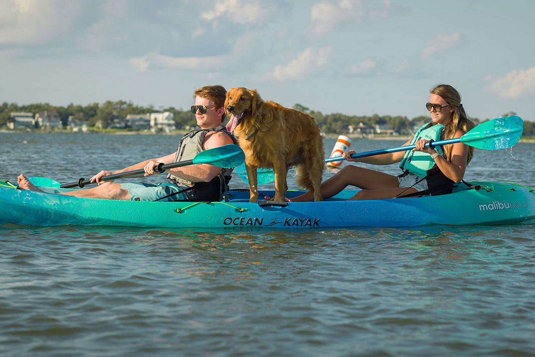 Man, woman and dog on sit-on-top tandem kayak