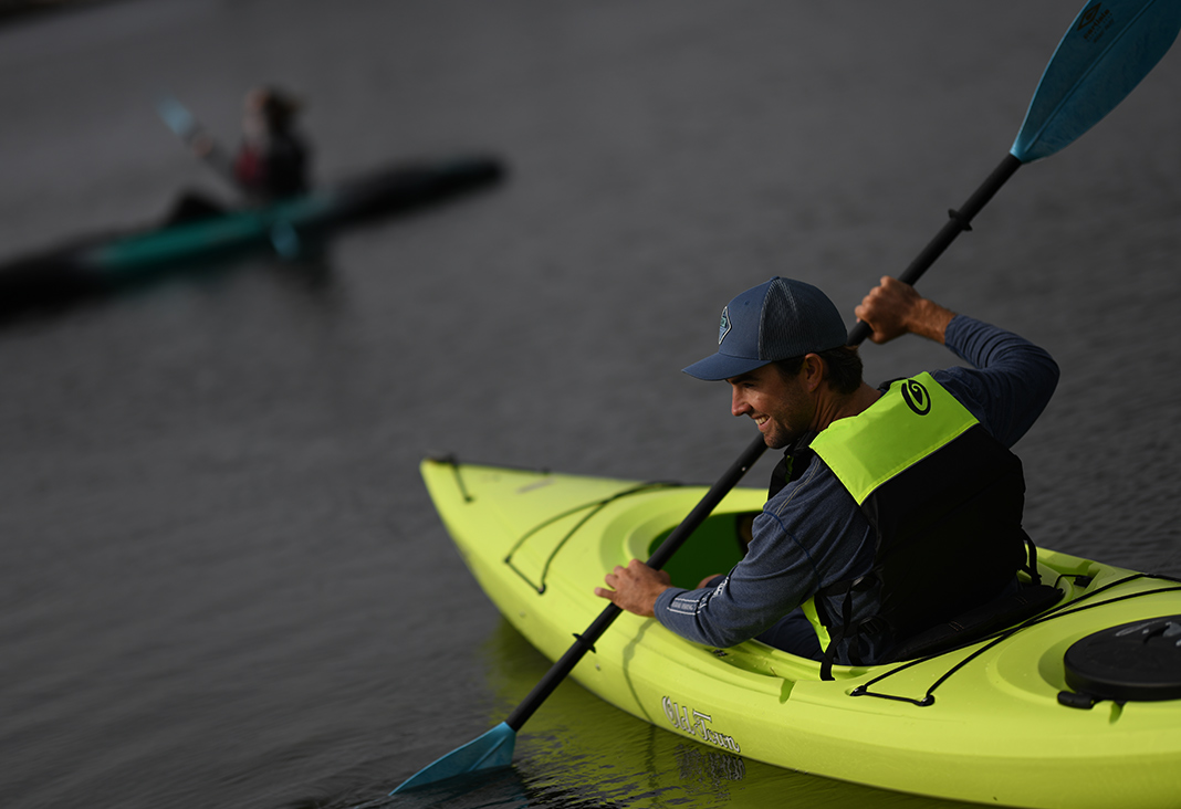 Man paddling green recreational kayak