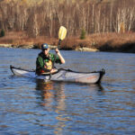 Folding Kayak Review: Oru Bay ST Man paddling folding kayak on a lake