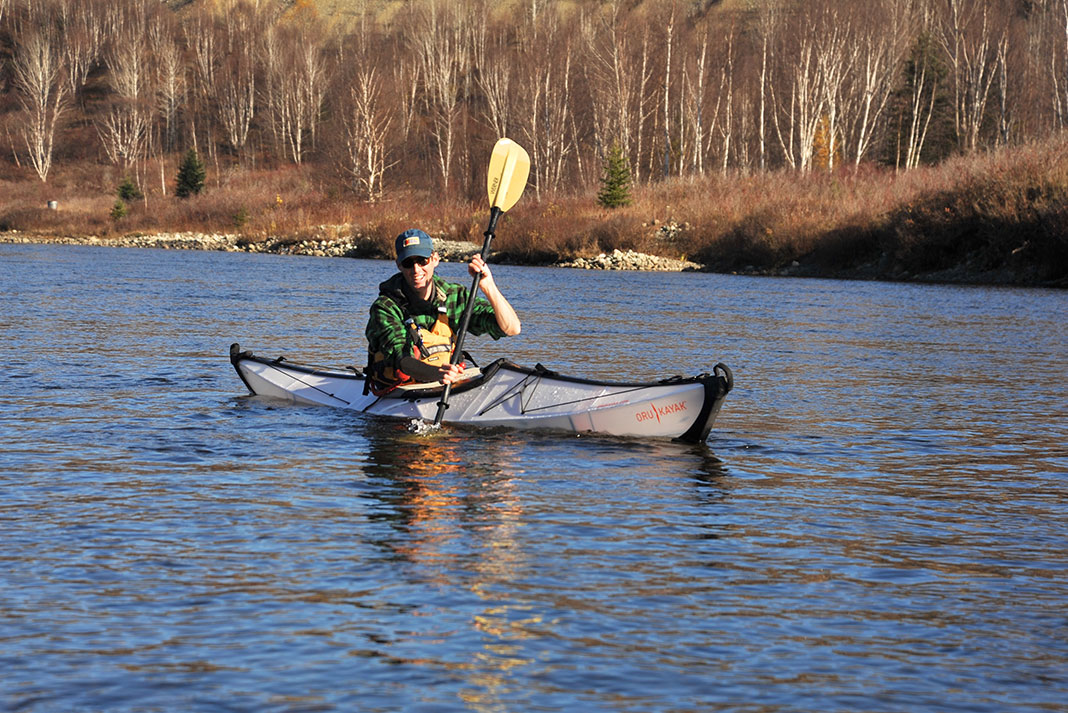 Man paddling folding kayak on a lake