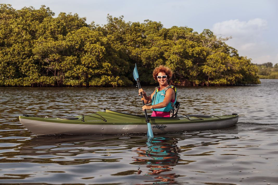Woman paddling green sit-inside rec kayak
