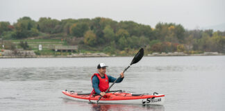 Man paddling red and white touring kayak