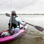 Recreational Kayak Review: Wilderness Systems Tarpon 100 Woman paddling purple sit-on-top kayak