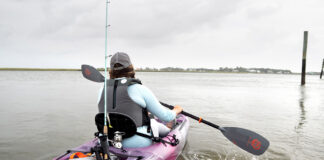 Woman paddling purple sit-on-top kayak