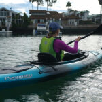 Recreational Kayak Review: Wilderness Systems Pungo 120 Woman paddling blue and black sit-in kayak