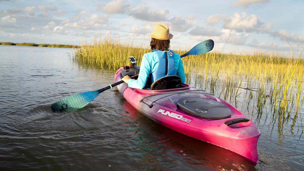 Woman paddles a sit-inside kayak