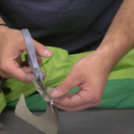 Expert Tips To Easily Fix Your Leaky Drysuit (Video) Man cuts patch to use to repair drysuit leak