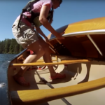 How To Empty A Swamped Canoe Using The Parallel Rescue (Video) a woman lifts a canoe to begin a parallel rescue