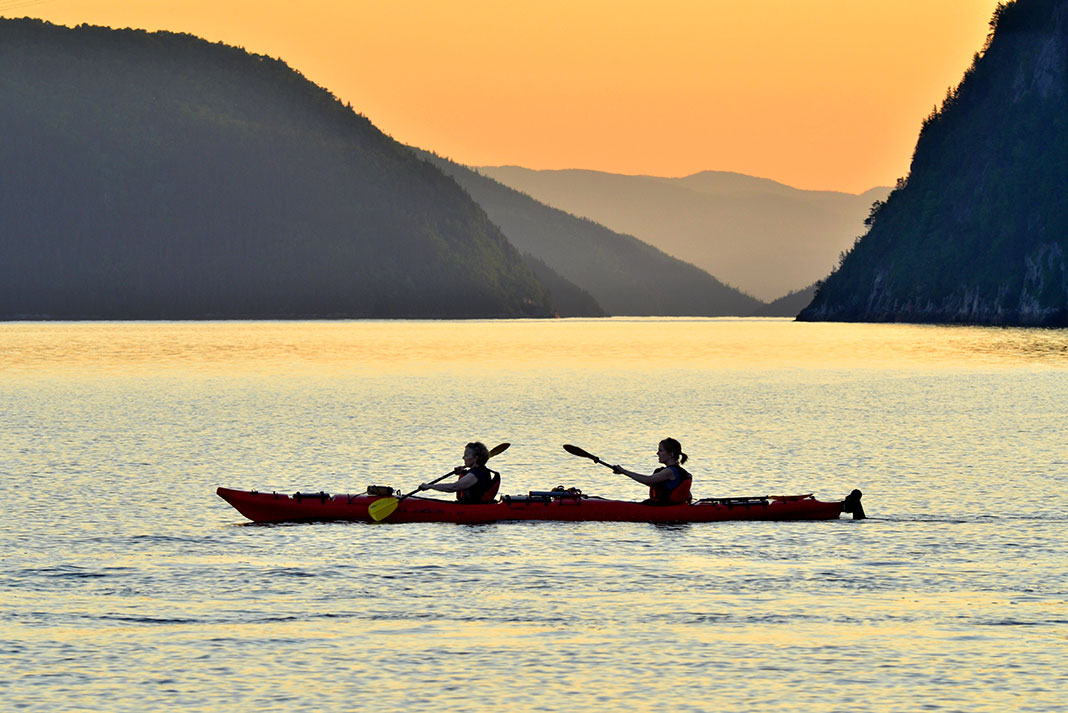 two people kayak at dusk in the Saguenay Fjord in Quebec