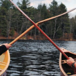 What’s Best? Bent Vs. Straight Shaft Canoe Paddles two canoeists hold up bent and straight shafted paddles