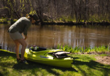 woman prepares a Sun Dolphin kayak to enter the water