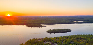 aerial view of sunset over calm Boundary Waters lake with accommodations in foreground
