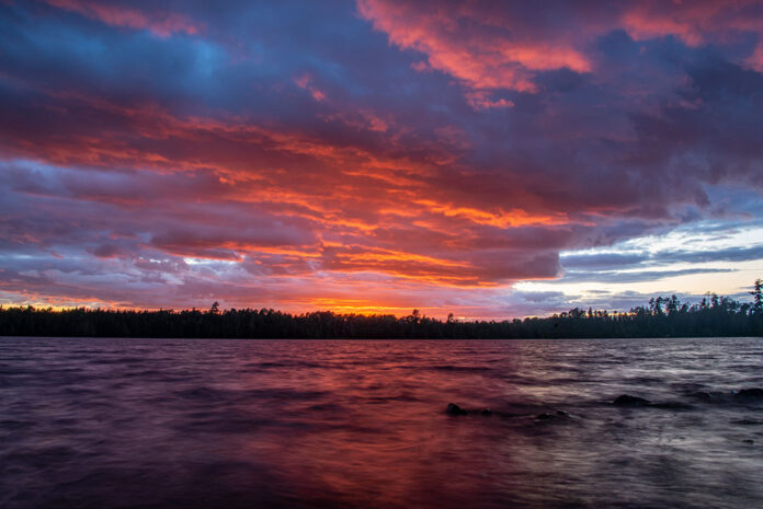 colorful sunset over a treed lake in Boundary Waters
