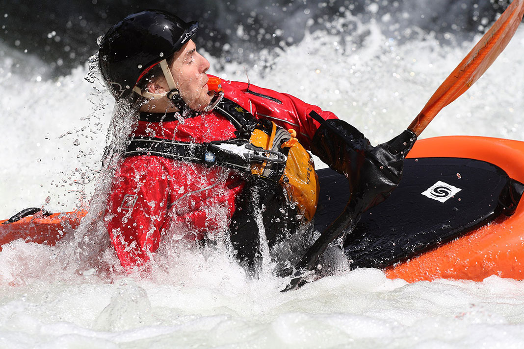 whitewater kayaker shows how to roll a kayak in aerated water