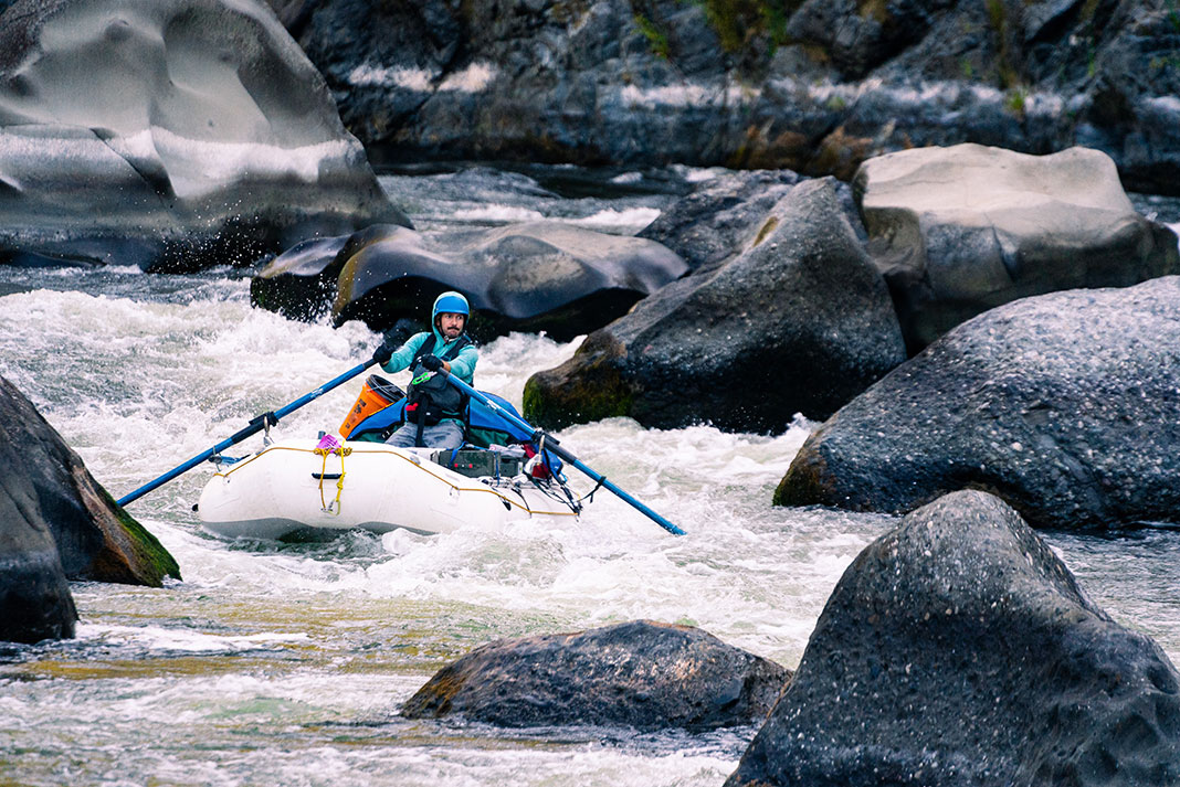 paddler man whitewater rafting through rocks and rapids