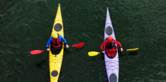 overhead view of one sea kayaker instructing another kayaker in paddlesports safety