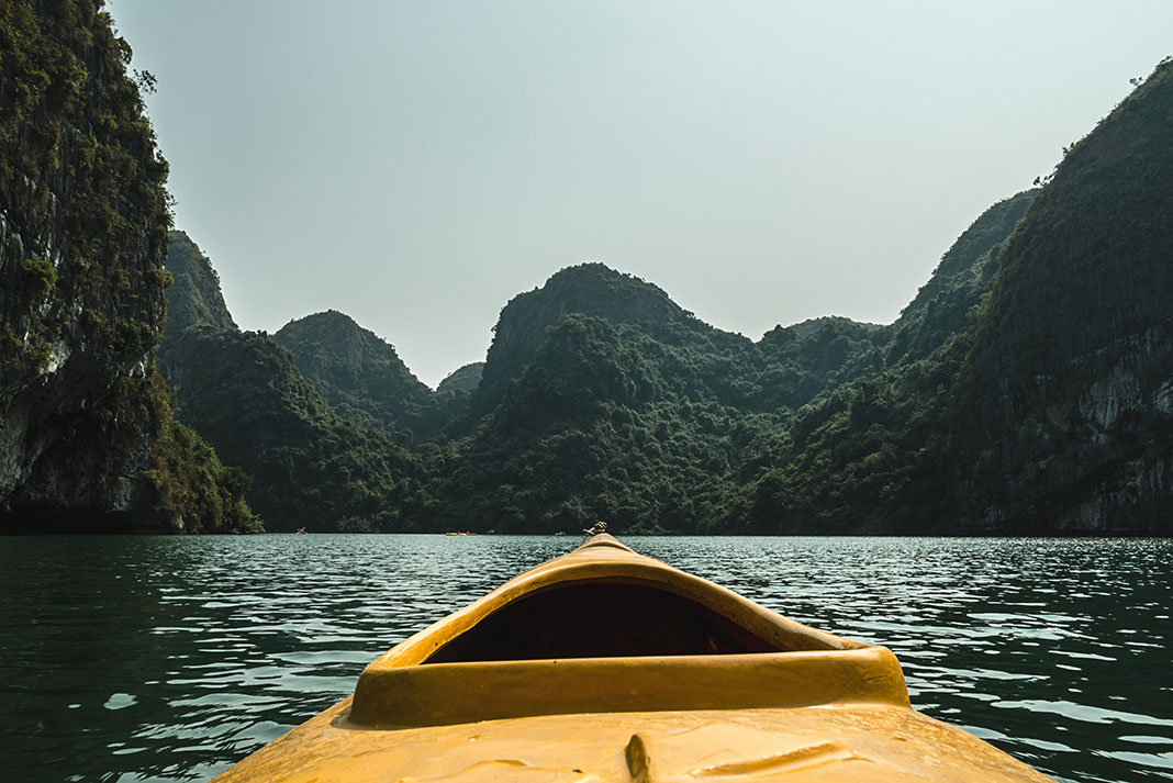 bow shot of a yellow kayak in Halong Bay, Vietnam on the trip of a lifetime