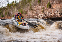 a group of whitewater rafters go over some rapids on a paddling dream trip