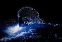 whitewater world champion Eric Jackson performs a freestyle move in dramatic blue lighting