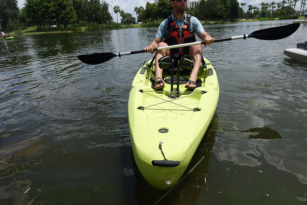 man sits in Hobie Passport R Series holding paddle at ICAST