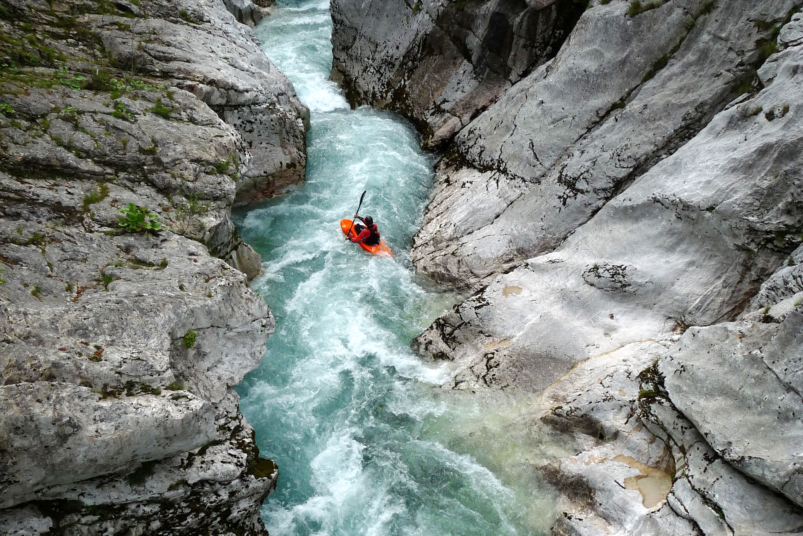 person whitewater kayaking in a gorge