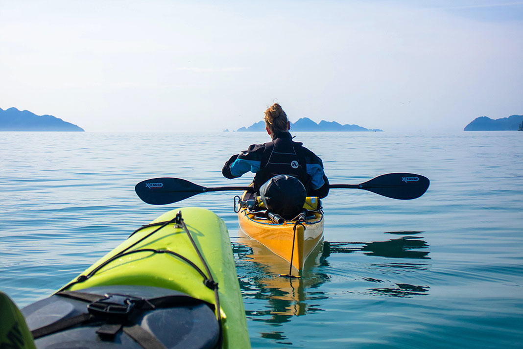 woman and another person travelling light in touring sea kayaks