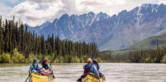 two yellow canoes paddle along the Nahanni River
