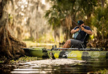 man fishes from a sit-on-top kayak with an all-around bass rod