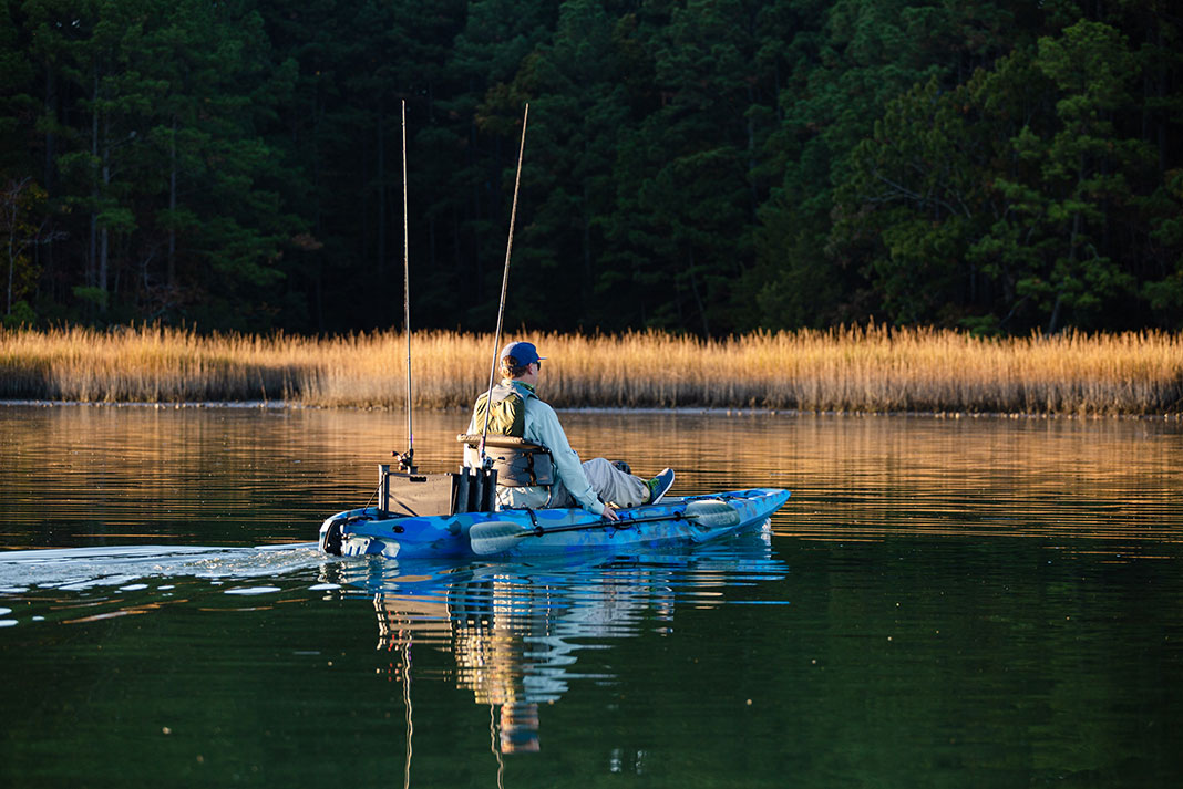 man pedals SeaStream 120 Angler fishing kayak